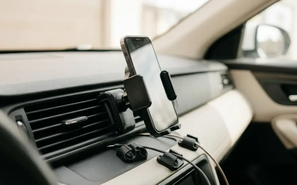 A black PETG phone holder on an air vent and cable clips in a car interior